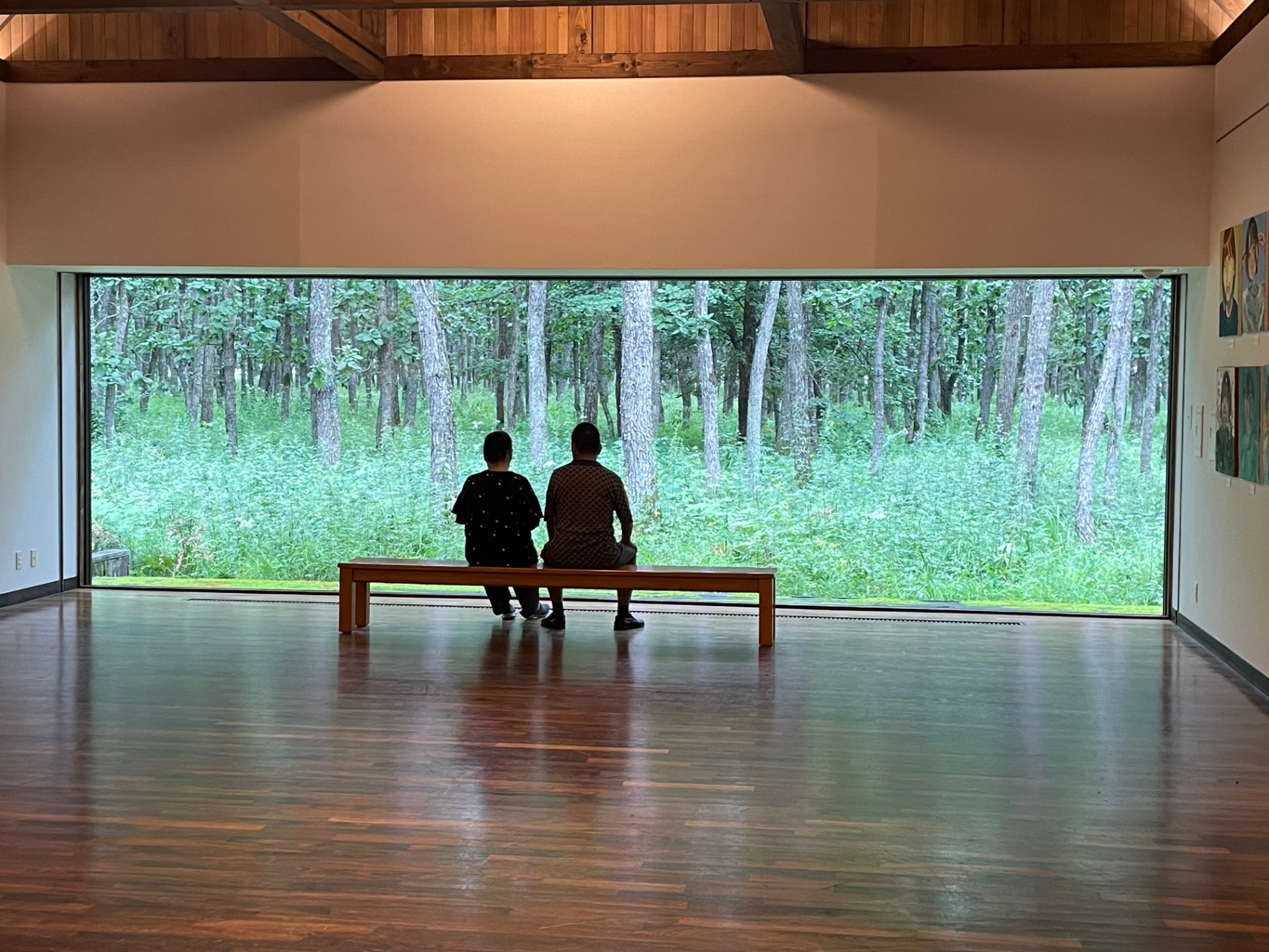 Couple seated quietly inside a Hokkaido forest-view gallery