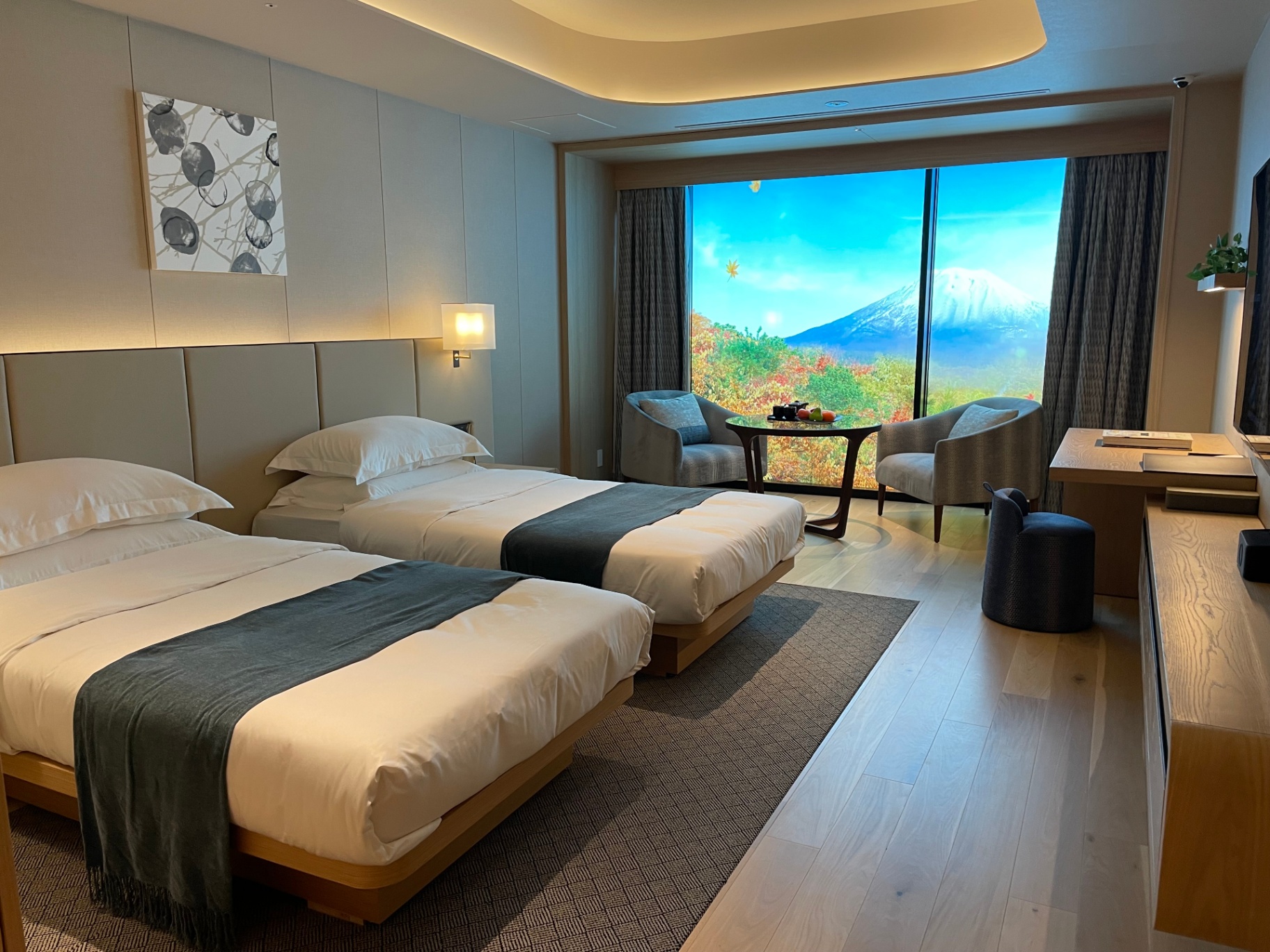 Twin-bed suite framing Mt. Yōtei across the Niseko valley in autumn