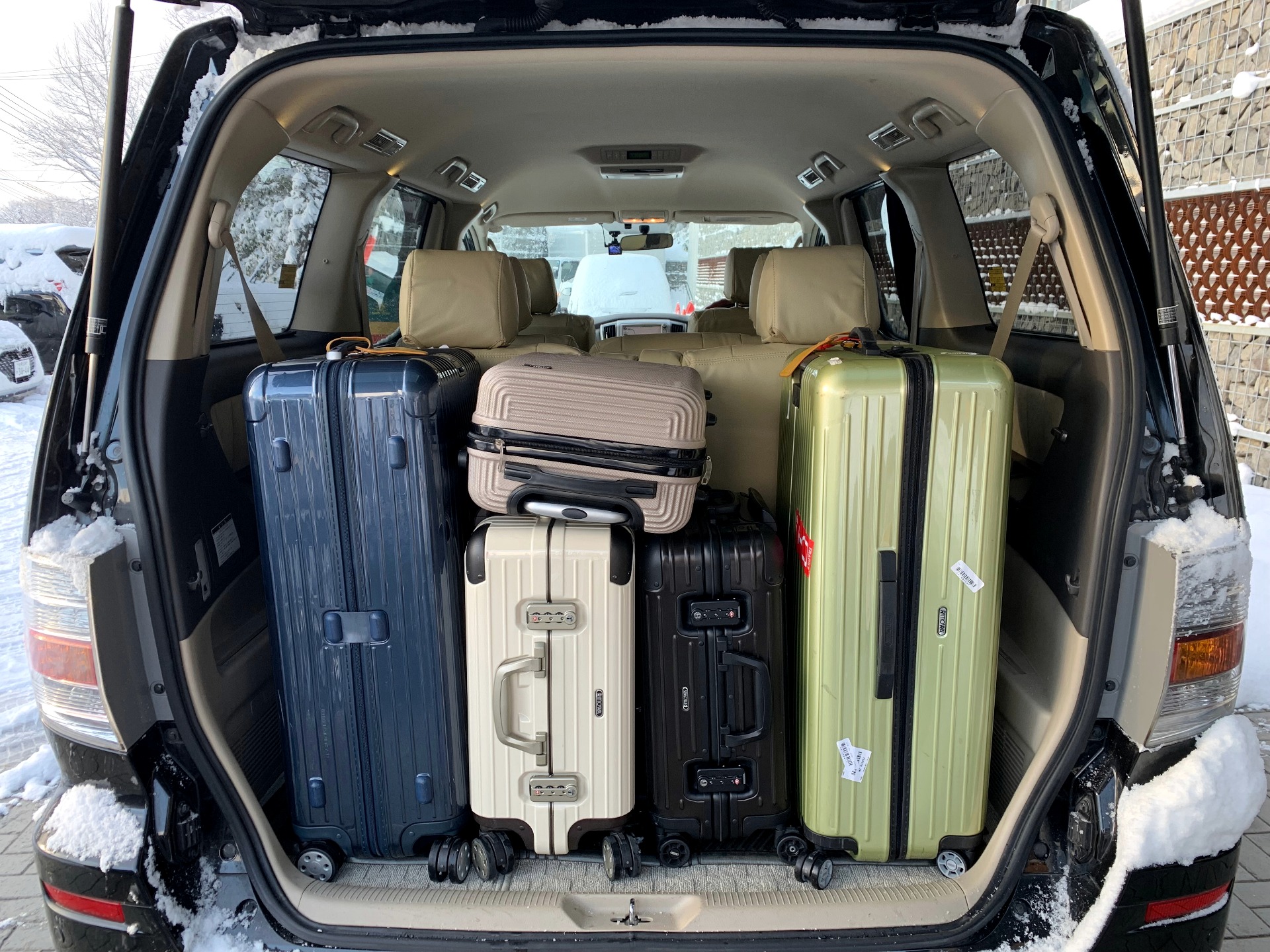 Winter airport-transfer luggage loaded neatly into a Toyota Alphard rear cabin