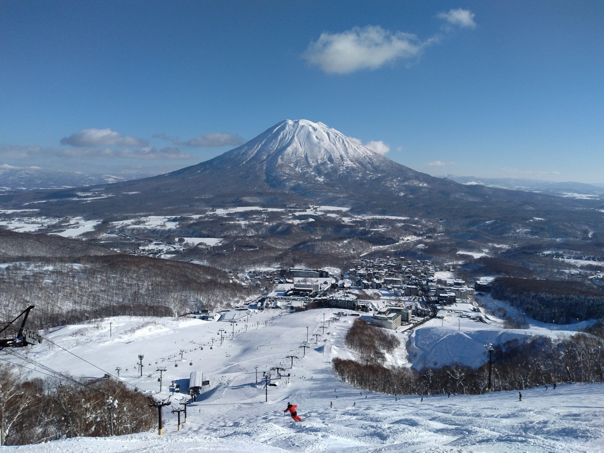 Snow-covered Niseko slopes and Mount Yotei beneath a clear winter sky