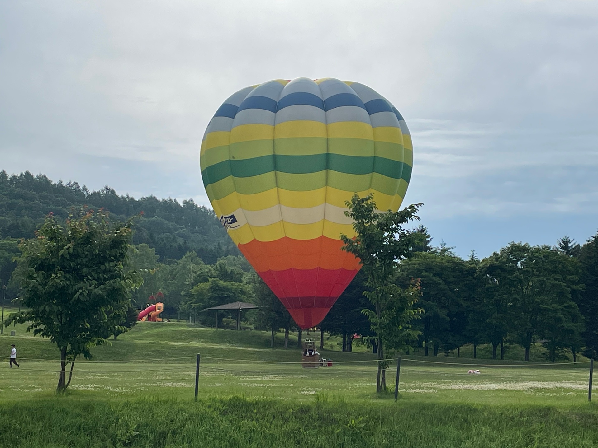 Colorful hot-air balloon rising over a green park in Hokkaido
