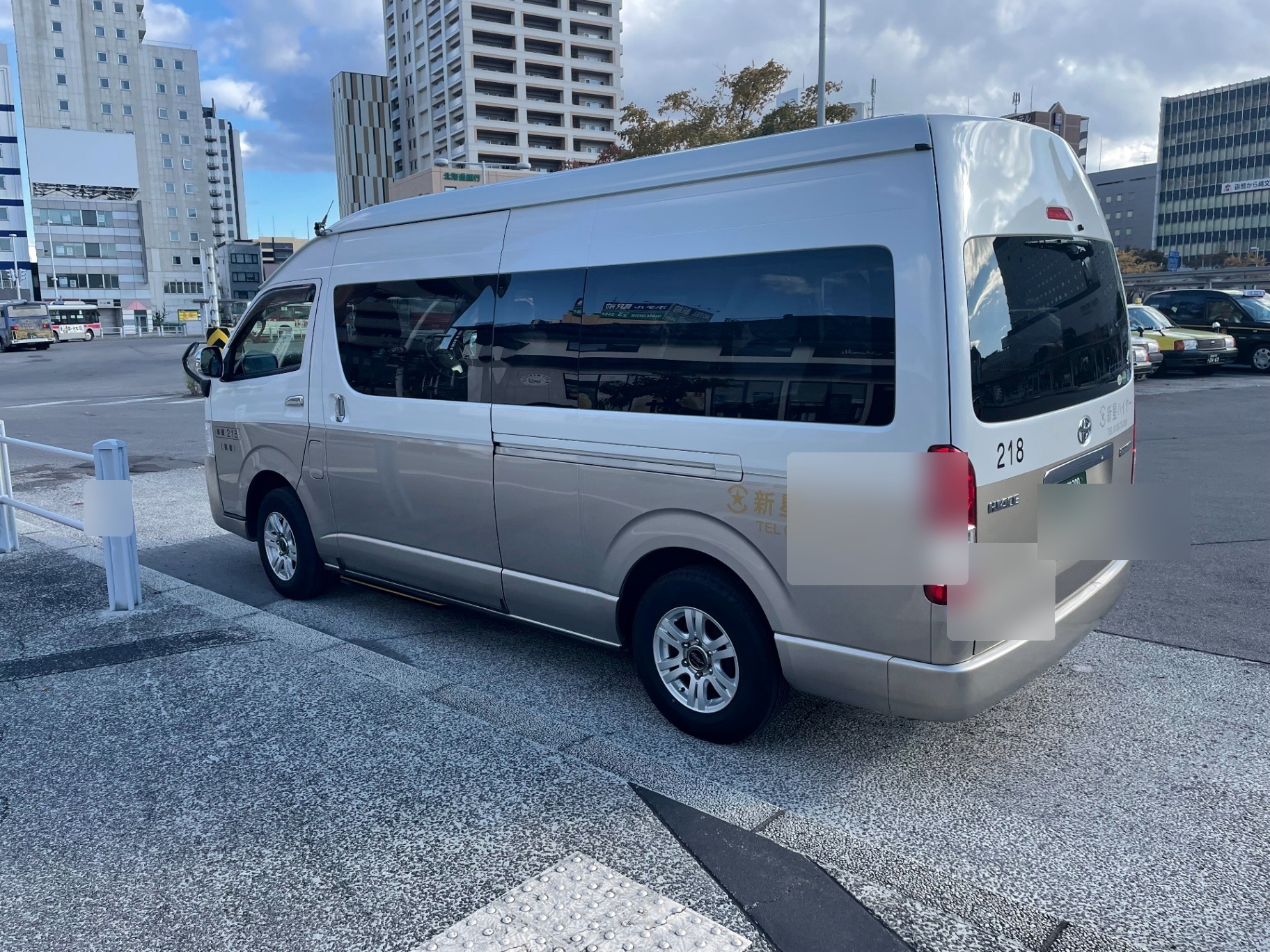 Toyota Hiace Grand Cabin transfer vehicle in an urban Hokkaido setting