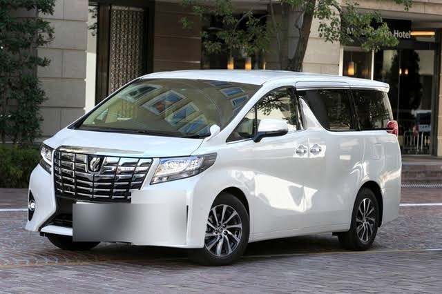 White Toyota Alphard executive transfer vehicle waiting outside a quiet Hokkaido hotel entrance