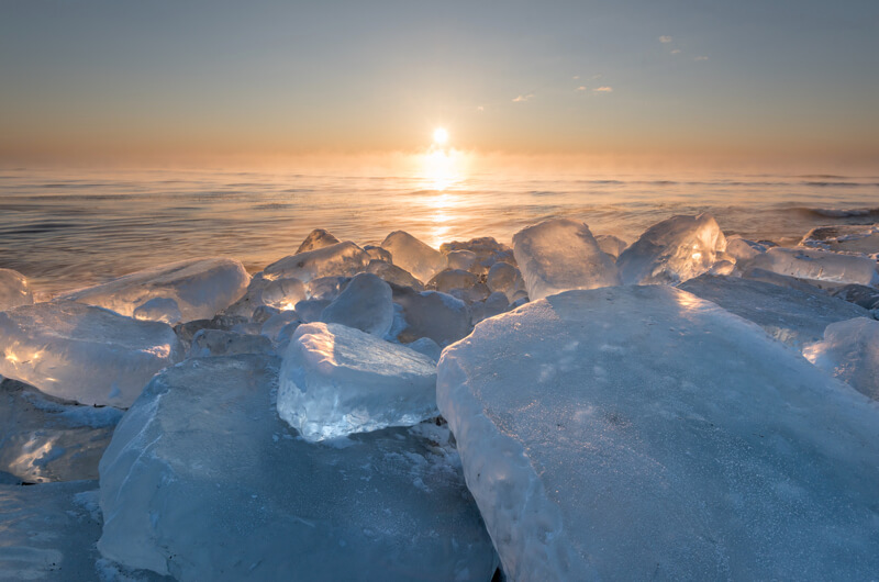 Hokkaido winter sunrise over the frozen sea — translucent ice on the shoreline