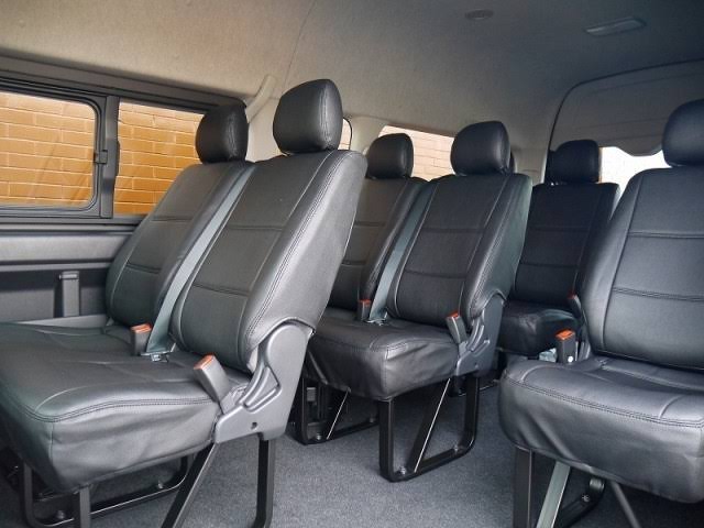 Rows of black leather seating inside a Toyota Hiace Grand Cabin group transfer