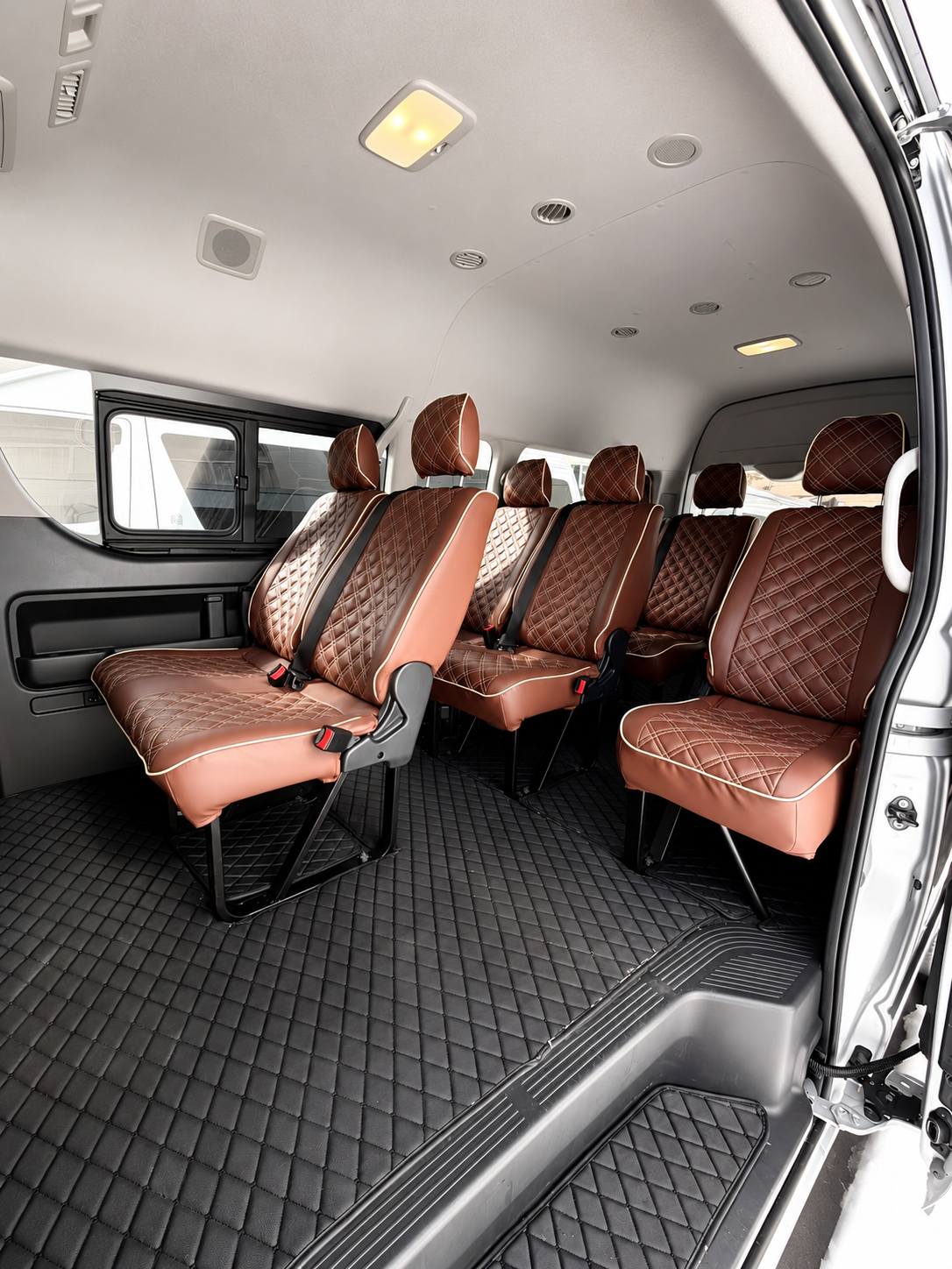 Toyota Hiace Grand Cabin interior with cognac diamond-stitched group seating and open side door