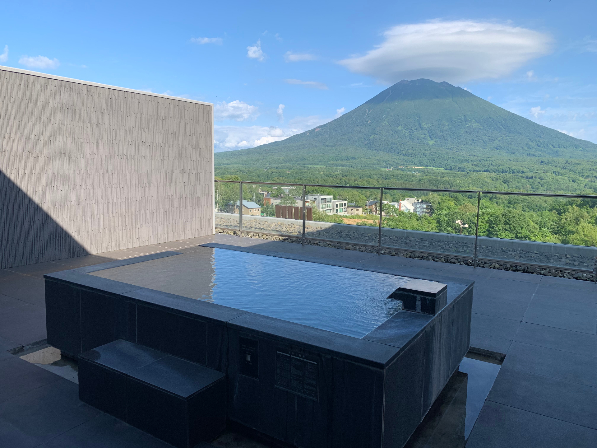Private onsen terrace overlooking Mt. Yōtei in summer green