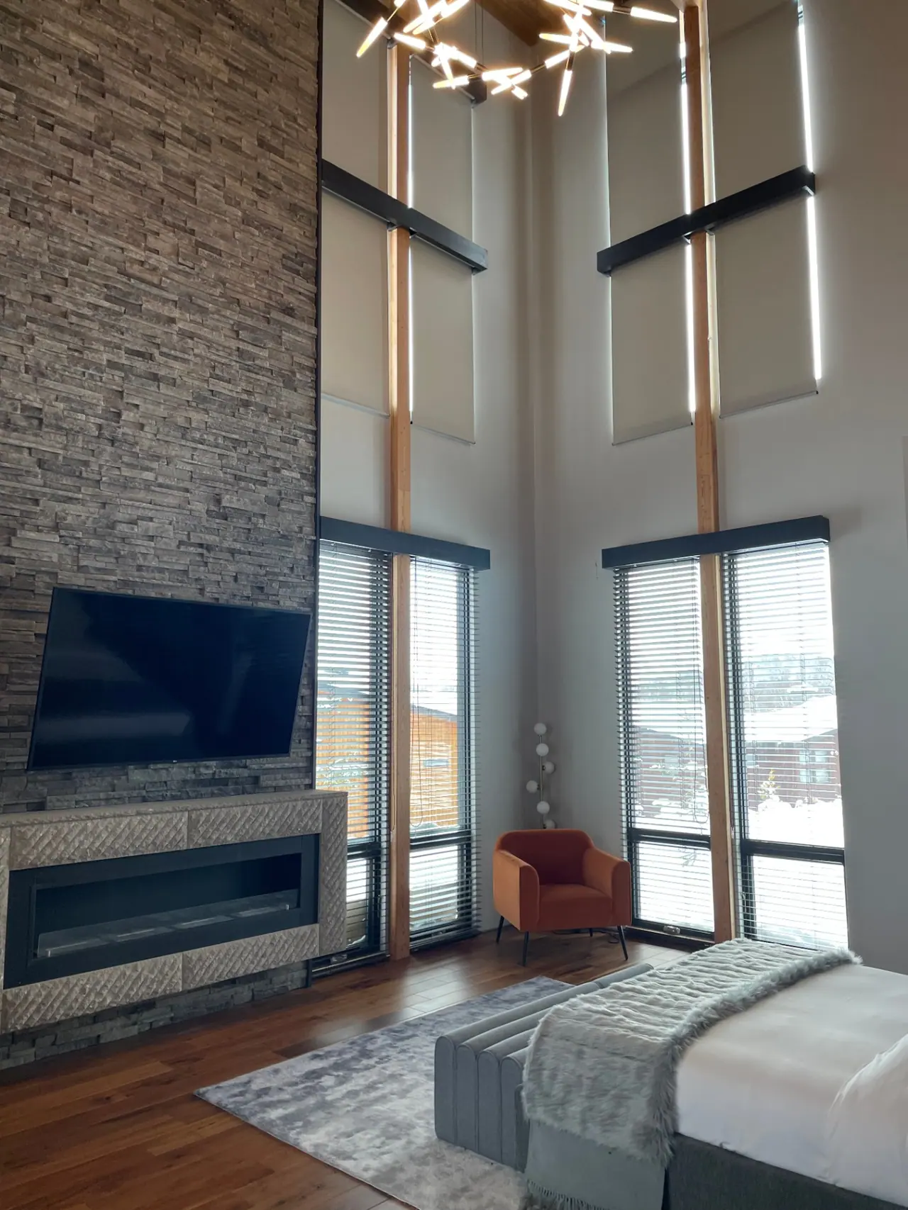 Double-height chalet living room with stone hearth and timber beams in Niseko