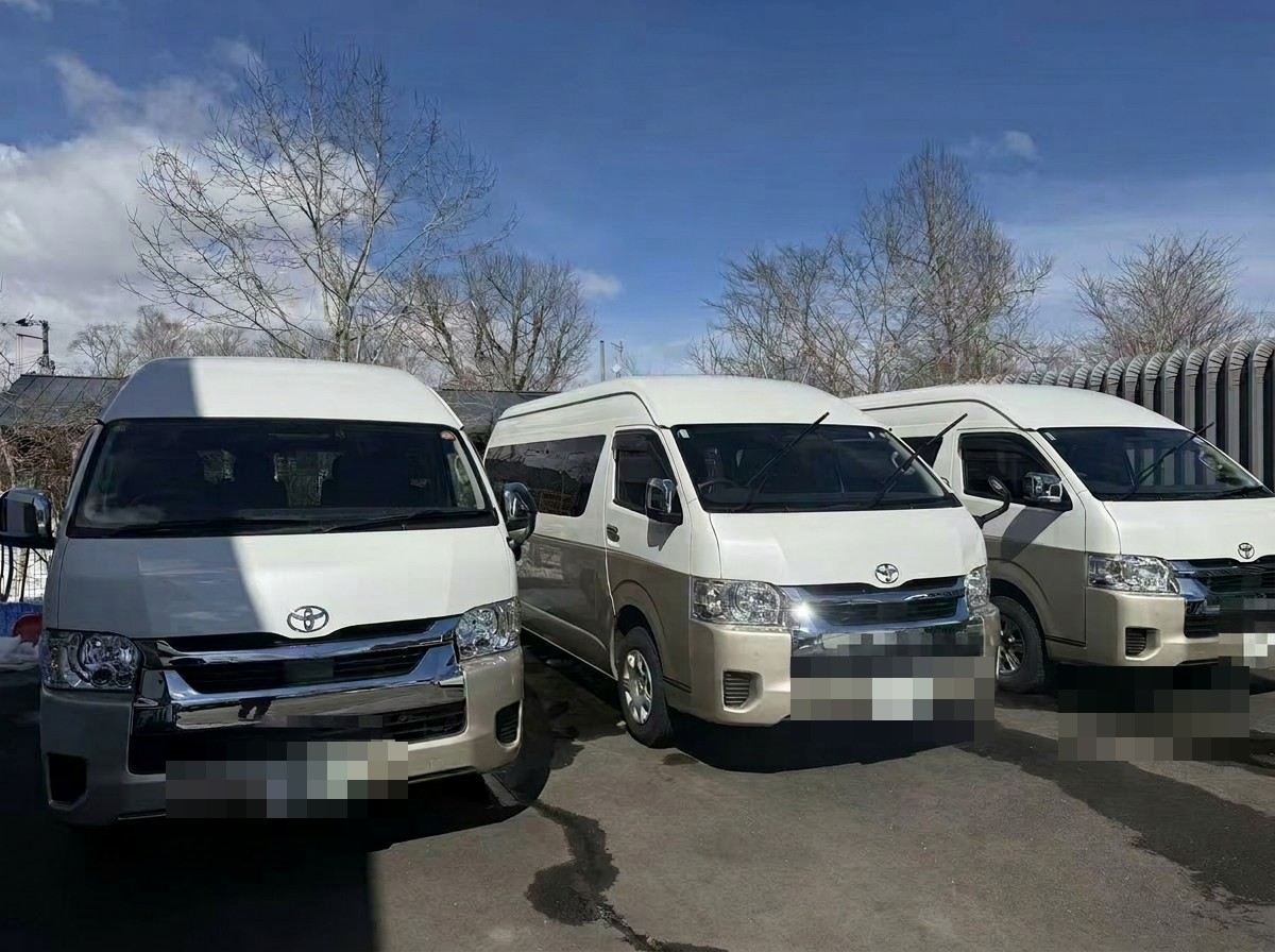 Toyota Hiace Grand Cabin group transfer fleet lined up in our Hokkaido lot (license plates masked for privacy)