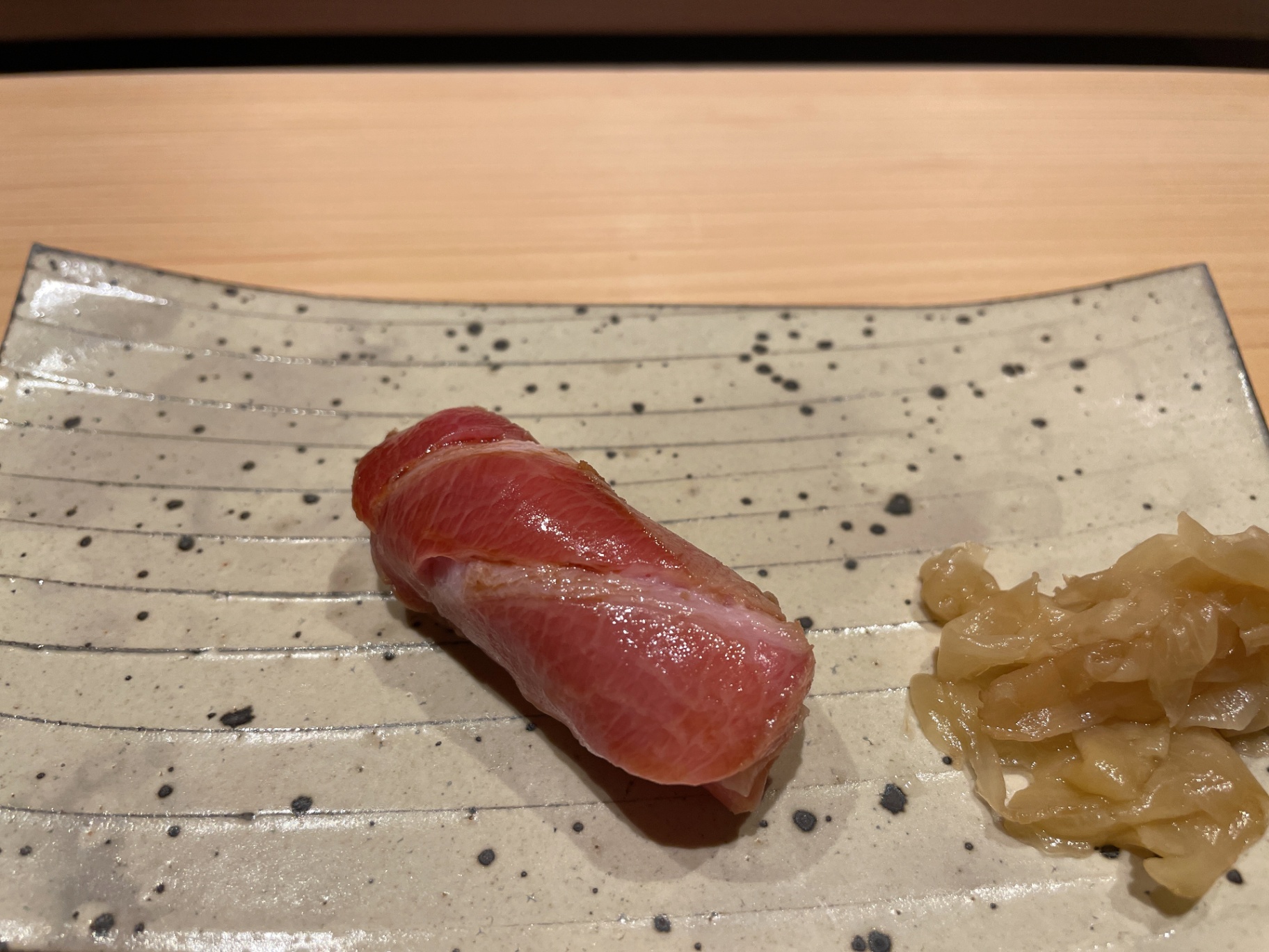 Hand-formed ōtoro nigiri on textured ceramic at a Sapporo sushi counter